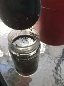 glass jar with soil being added